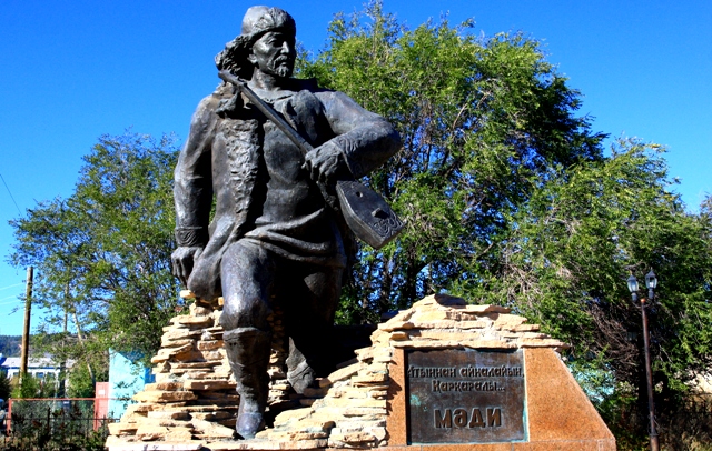 Памятник акыну Мади в центре поселка.