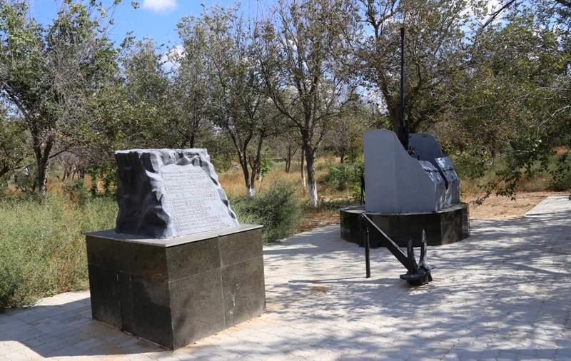 Зенитное орудие и памятная доска в парке города Форт-Шевченко.