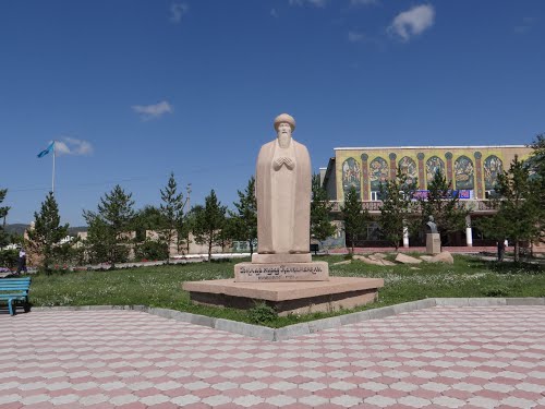 Памятник Бухар Жирау Калкаманулы и чуть в стороне "Дом культуры" имени С. Торуайгырова.