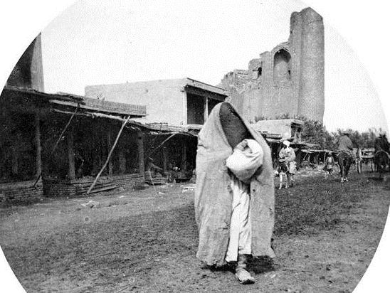 The woman in a veil on a background of mosque Bibu Khanym. Photographer Paul Nadar.