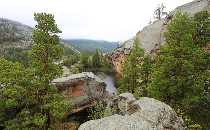 Peaks of rocky mountains are covered with a wide network of lakes in granite depressions.