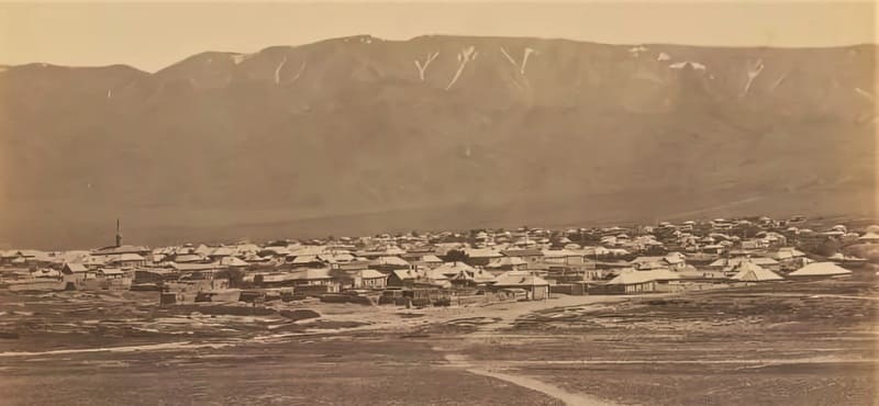 0_13. Николай Креков. На снимке 1877-1878 г.г. изображен общий вид города Копала на фоне горной панорамы (имеется еще 2-я часть фотографии «Семиреченская область. Город Копал»). Слева – виден минарет татарской «верхней» мечети, находящейся в собственно городском поселении, где-то в районе Татарской слободки; справа располагается казачья станица, ограниченная с двух сторон водной преградой в виде речек – Копалки и Зимовки, с родником Тамчи-булаком. Видны также дороги, ведущие как в поселение, так и мимо него, т.н. почтовый тракт из Семипалатинска до Верного.