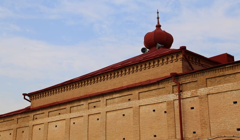 Nogai Ishan Mosque. The building has a red dome and decorative elements on the roof. 2024