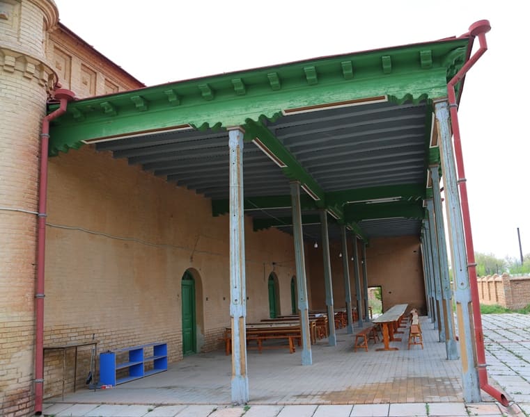 Nogai Ishan Mosque. A long iwan (covered gallery) with wooden columns supporting a green beamed roof. 2024