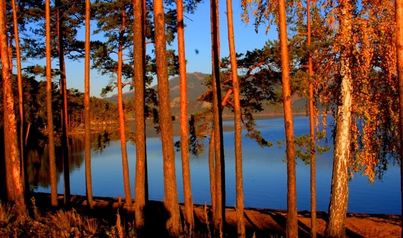 Dawn on Lake Borovoe. Water in lake is very clear, and its shores are covered with coniferous forests, which gives lake its name (from Russian word "bor").