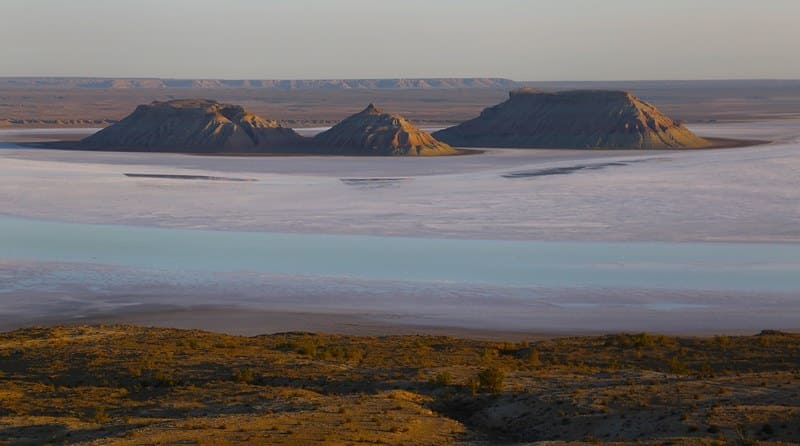 In the northwestern part of the Karynzharyk Depression are the Ysh Batyr (Russian: Three Batyrs) outliers. The northernmost outlier reaches a height of 116.7 meters, the eastern outlier 79.7 meters, and the western outlier 83 meters. The bottom of the outlier is always wet and covered with a salt crust, which bulges in the sun into veins of endless cracks. During wet seasons, the salt marsh is covered with a thin layer of water, and then the outliers, like inaccessible islands, rise above the mirror-like surface.