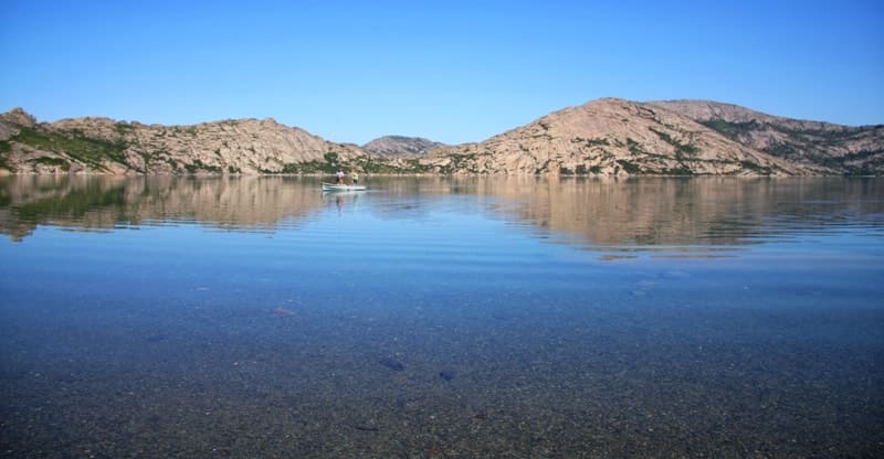 The contrast of the clear granite lines and the soft surface of the water emphasizes the character of these lakes.