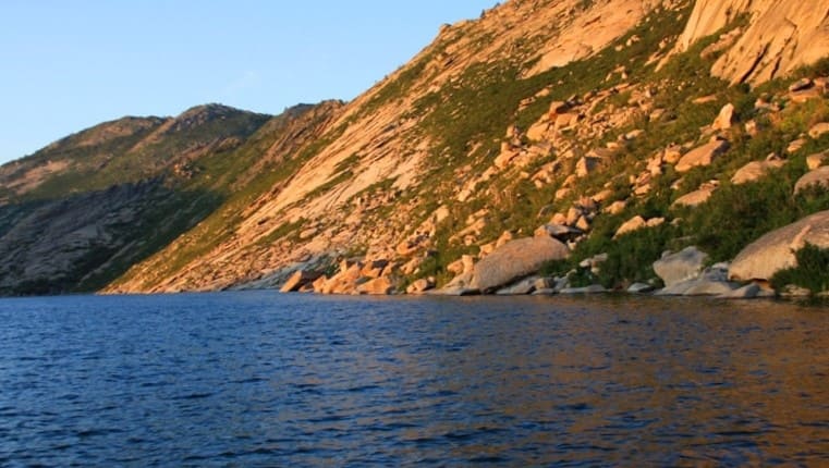 A rocky shore with randomly scattered boulders - a trace of ancient tectonic processes.