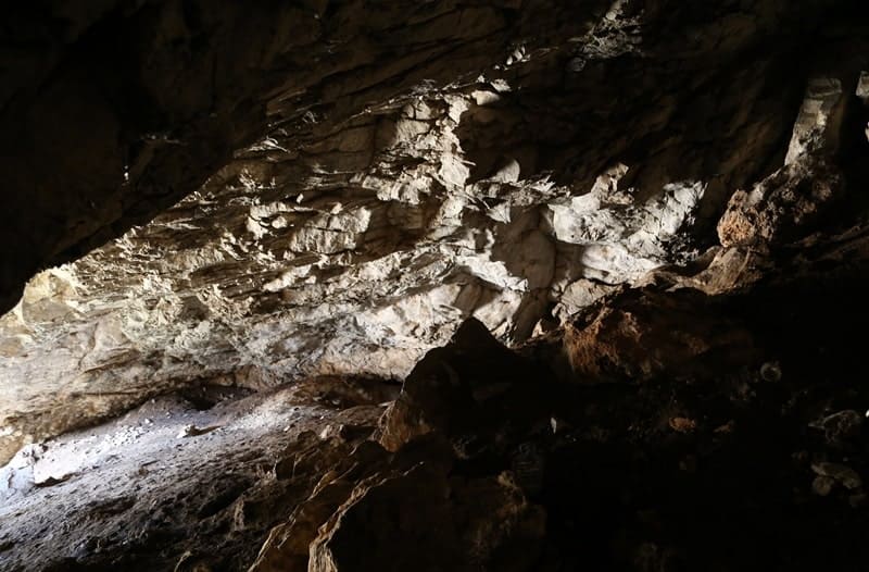 There is virtually no platform in front of the entrance to the Aktogay Cave; a steep rocky ledge begins immediately at the drip line, forming the valley wall.