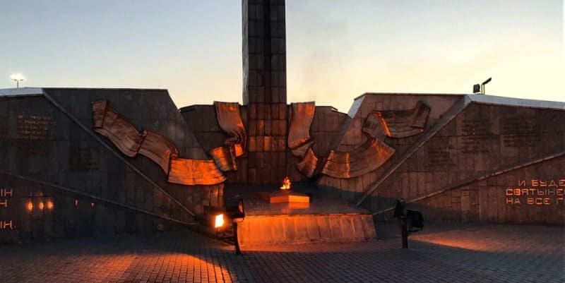 Памятник Славы в Усть-Каменогорске, на закате. Мемориал посвящен павшим в Великой Отечественной войне. В центре композиции горит Вечный огонь. Памятник выполнен в стиле социалистического реализма и включает драматические барельефы. Памятник расположен в Парке Победы.