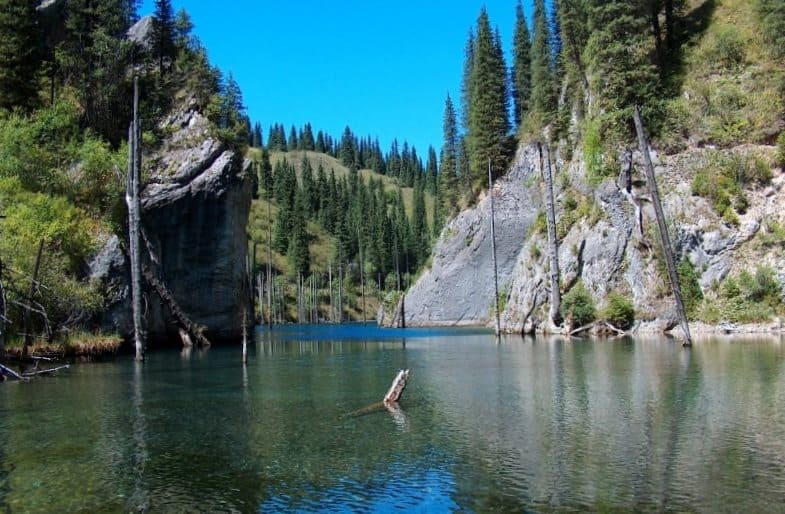 Ландшафт озера Каинды поражает сочетанием суровых каменных склонов, хвойных массивов и бирюзовой глади уникального водоёма.