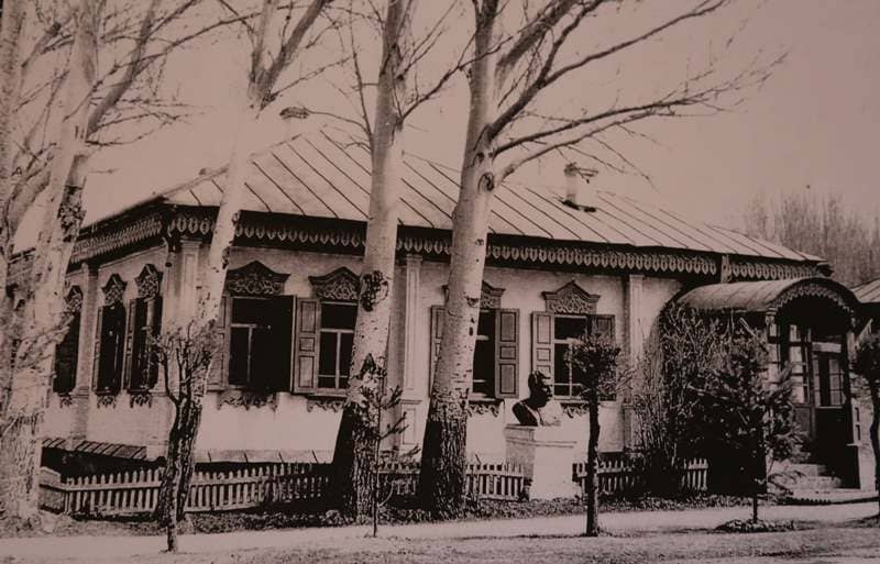 Former private residential house of merchant V.G. Rafikov on the corner of Toktogul and Zhamansariyev streets in city of Karakol. In front of the house, in front garden, there is a bust of N.M. Przhevalsky. 1950s. Photographer unknown.