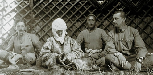 Момент встречи полковника Российской императорской армии Карла Густава Маннергейма с «Алайской царицей» Курманжан Даткой. Снимок был сделан летом 1906 года, незадолго до смерти правительницы. На снимке также присутствует внук Курманжан Датка, сидящий за спинами царицы и Маннергейма. Маннергейм, проводивший разведывательную экспедицию, посетил Курманжан Датку в её юрте, чтобы запечатлеть её на фото.