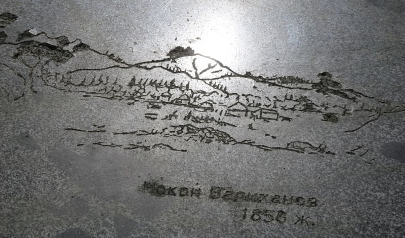 The stone features an engraved image of a mountain landscape and a commemorative inscription related to Valikhanov’s 1856 expedition. 2002.