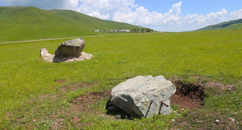  Memorial stones with the small village of San-Tash in the background. Tyup District, Issyk-Kul Region. 2002.