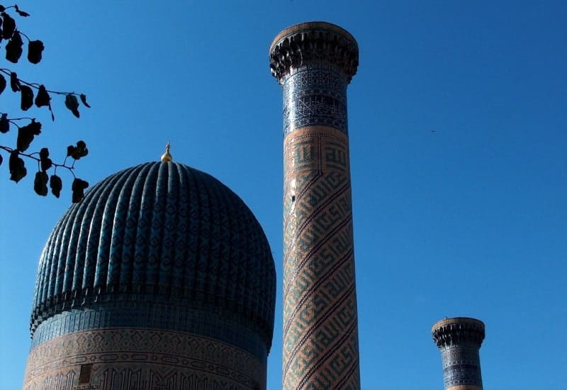 По сторонам купола возвышаются две мощные высокие колонны, сложенные из кирпича.