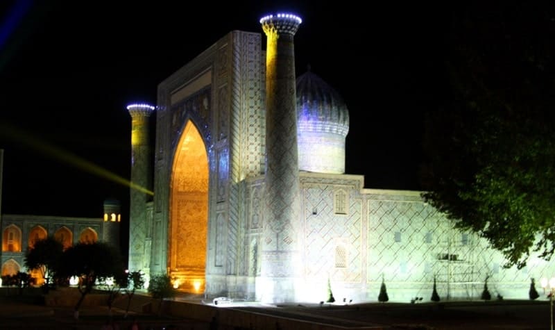 The Ulugh Beg Madrasah illuminated at night.