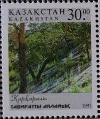 Stamp depicts Karkaraly National Park in Kazakhstan. Protect nature.